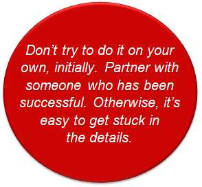 Don't try to do it on your own, initially. Partner with someone who has been successful.